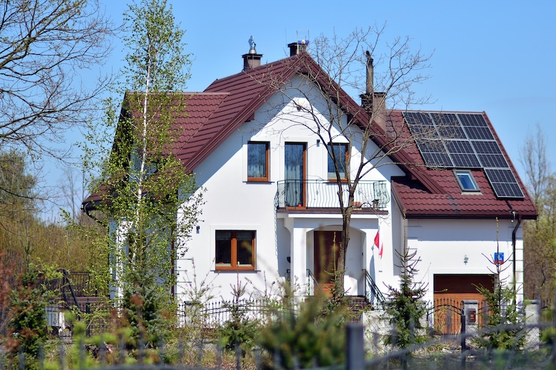 Vit villa med solceller på det röda tegeltaket